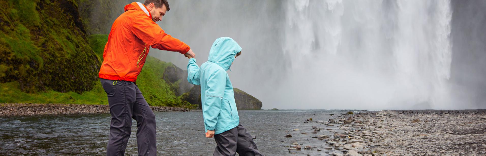Far og søn besøger vandfaldet Skogafoss på Island