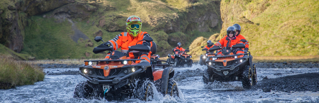 ATV'er krydser en flod i Islands vilde natur.