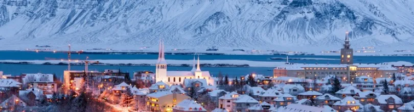 Snedækket Reykjavík med bjerge i baggrunden.