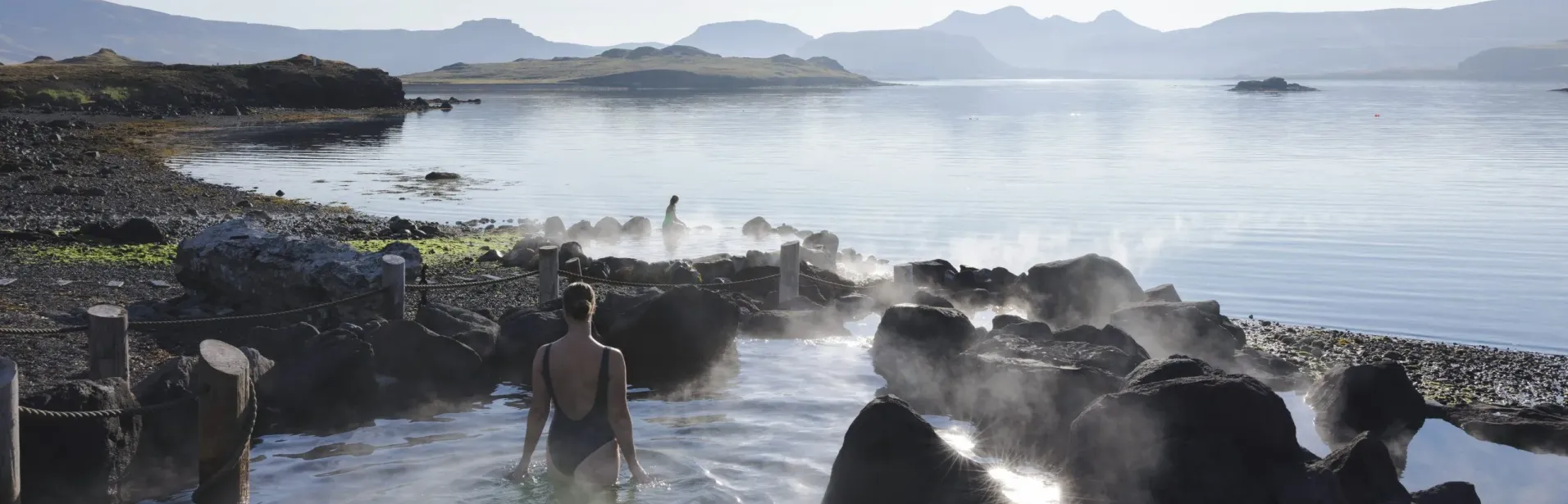 Badegæst i geotermisk pool ved havet i Hvammsvík.
