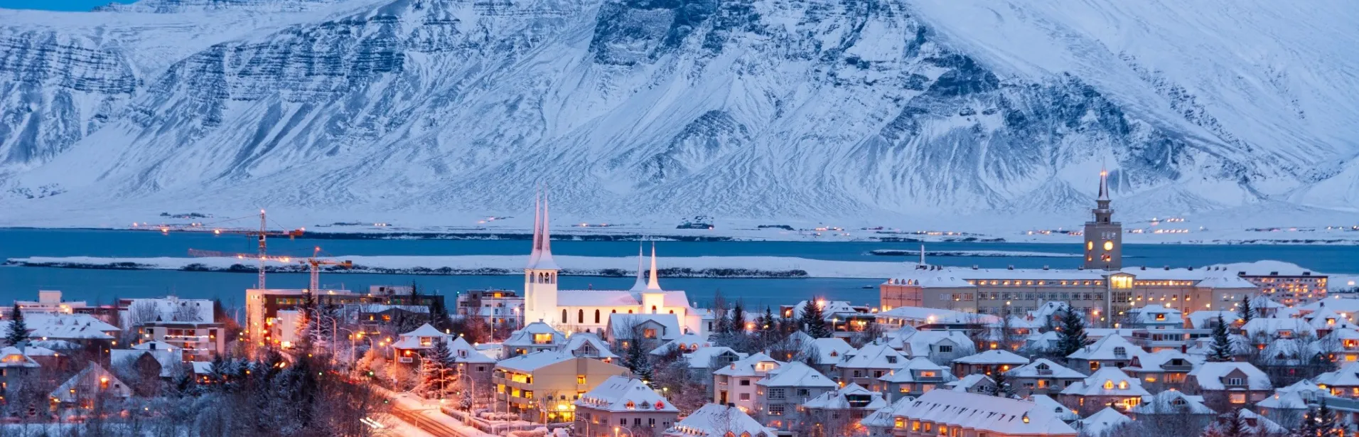 Snedækket Reykjavík med bjerge i baggrunden.