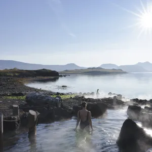 Badegæst i geotermisk pool ved havet i Hvammsvík.
